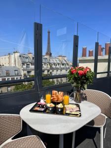 uma bandeja de comida sentada numa mesa numa varanda em Rayz Eiffel em Paris