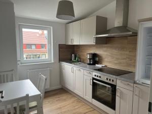 a kitchen with white cabinets and a stove top oven at Living Time in Bremen