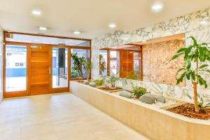 un vestíbulo de oficina con una zona de espera con plantas en MAGNÍFICO APARTAMENTO - primera línea de mar, en Calafell