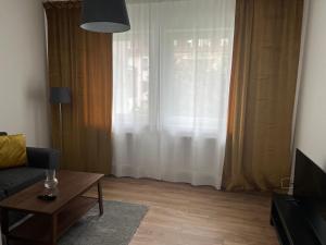 ein Wohnzimmer mit einem Sofa, einem Tisch und einem Fenster in der Unterkunft Holiday Home in Bremen