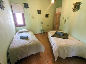 een kamer met 2 bedden in een kamer met een raam bij Finca La Libertad in Coín