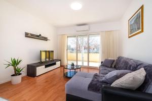 a living room with a couch and a tv at Apartments Sandra in Turanj