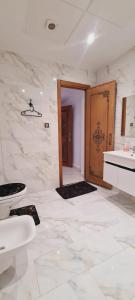 uma casa de banho com um WC, um lavatório e uma porta em Hotel Palace tanger em Tânger