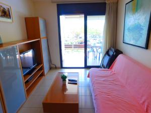 een slaapkamer met een bed en een televisie en een tafel bij GMID IMMO Apartment Mileni in Roses