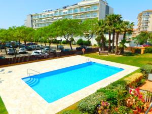 a swimming pool in a yard with a large building at GMID IMMO Apartment Mileni in Roses