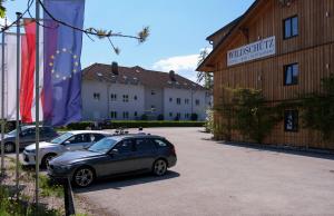 two cars parked in a parking lot next to a building at Aktivhotel Wildschütz in Altmünster