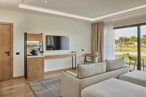 a living room with a couch and a television at Meliá Durrës Albania in Durrës