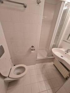 a white bathroom with a toilet and a sink at 10Q - Z6 Apartment 205 in Warsaw