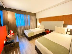 A bed or beds in a room at eSuites Hotel Recreio Shopping