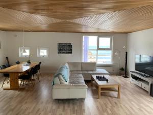 a living room with a couch and a table at Dejlig og et godt hus, Hotel in Sisimiut