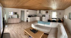 a living room with a couch and a table and a kitchen at Dejlig og et godt hus, Hotel in Sisimiut