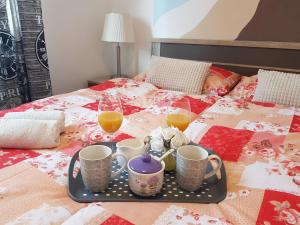 a tray with two glasses of orange juice and two cups on a bed at Mediterranean ocean view 4star appartment in Villa in Rijeka