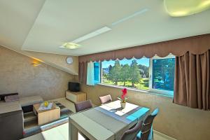 a living room with a table and chairs and a window at Apartments Riva-Interauto in Umag
