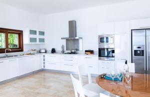a kitchen with a wooden table and white cabinets at The Korsan Kuzey in Kas