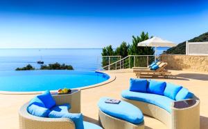 a patio with blue chairs and a swimming pool at The Korsan Kuzey in Kas