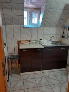 a small kitchen with a sink and a mirror at Vila Coca in Predeal