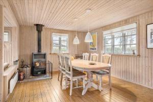 オテルプにあるLovely Holiday Home On The Beach At Tørresøのテーブルと椅子とコンロのあるキッチン