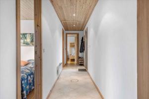 オテルプにあるLovely Holiday Home On The Beach At Tørresøのベッドと木製の天井のある廊下