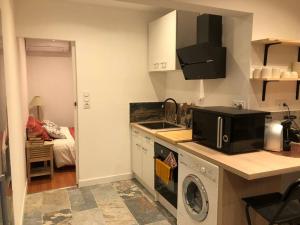 eine kleine Küche mit Spüle und Mikrowelle in der Unterkunft Charmant T2 climatisé - Près des plages in Narbonne + 4 Fotos