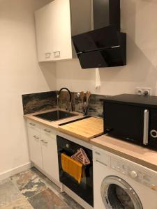 eine Küche mit Spüle und Waschmaschine in der Unterkunft Charmant T2 climatisé - Près des plages in Narbonne