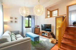 a living room with a couch and a tv at Villa vacacional Taty in Llanes