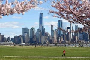 une femme se promenant dans un parc avec vue sur une ville dans l'établissement Sweet Home - 20 minutes to NYC, à Jersey City
