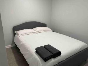 - un lit blanc avec 2 serviettes noires dans l'établissement Sweet Home - 20 minutes to NYC, à Jersey City