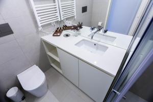 Un baño blanco con lavabo e inodoro. en Oporto City View - Guest House Suites, en Oporto