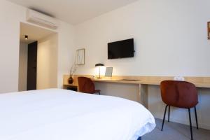 Un dormitorio con una cama y un escritorio con dos sillas. en Oporto City View - Guest House Suites, en Oporto