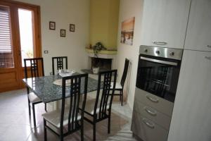 een keuken en eetkamer met een tafel en een koelkast bij La Rosa del Salento in San Cesario di Lecce