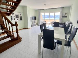 a dining room and living room with a table and chairs at Park Raxo in Raxó