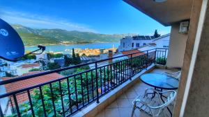 a balcony with a table and chairs and a view of the water at Apartmani Cupic in Budva