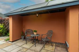 a covered patio with two chairs and a table at Ellistown Retreat in Hugglescote