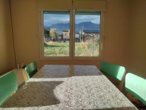 Pokój ze stołem i dużym oknem w obiekcie Sueños de Montaña w mieście Esquel
