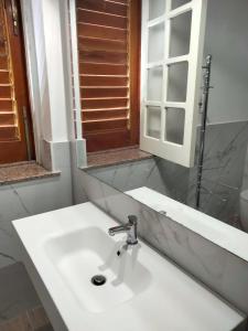 bagno con lavandino bianco e specchio di La casa di Elisa villa con piscina a San Leone