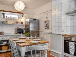 ウィットビーにあるSeaside Cottageのキッチン(テーブル、椅子、冷蔵庫付)