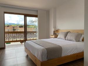 a bedroom with a large bed and a balcony at Hotel Gran Plaza San Agustin in San Agustín
