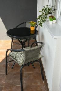 ein schwarzer Tisch und Stuhl neben einem kleinen Tisch und Stuhl in der Unterkunft Apartman Harmony in Sombor