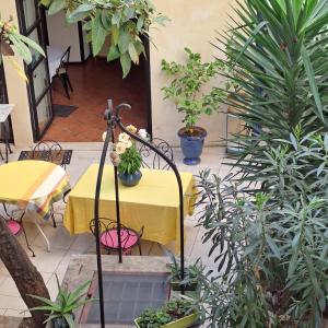 a table with a yellow table cloth and some plants at SOUS LE NEFLIER in Nîmes