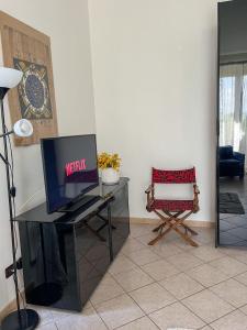 sala de estar con TV y silla en La Villa, Tiburtina Valley, en Roma