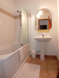 uma casa de banho branca com um lavatório, uma banheira e um espelho. em MAISON ALBA ROSSA 55 em Serra-di-Ferro