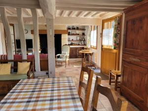 a kitchen with a table and chairs and a living room at La Porterie face à l'abbaye in Le Bec-Hellouin