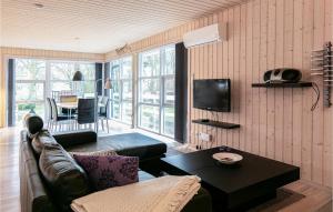 uma sala de estar com um sofá e uma mesa em Beautiful Home In Rnne With Wifi em Rønne