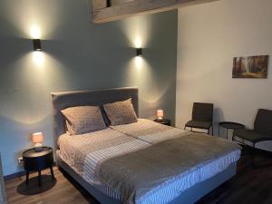ein Schlafzimmer mit einem Bett mit zwei Stühlen und zwei Lampen in der Unterkunft De Heide in Odoorn