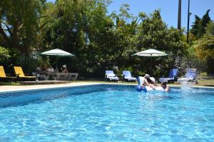 dos personas están sentadas en una piscina en Villa Lagos Algarve for families & friends, 6 bedrooms, 7 bathrooms, pool, BBQ, central heating en Pedra Alçada