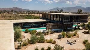 ein Haus inmitten einer Wüste mit Pflanzen in der Unterkunft Hotel Los Amantes Valle de Guadalupe in Valle de Guadalupe