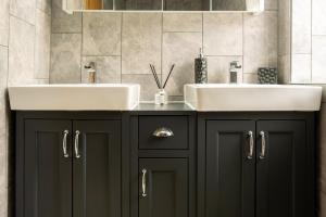 un bagno con 2 lavandini e armadi neri di Exclusive House with Canadian Hot Tub a Great Yarmouth Altre 20 foto