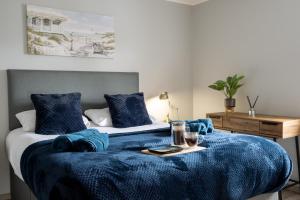 due letti con coperte blu e un vassoio sopra di Exclusive House with Canadian Hot Tub a Great Yarmouth