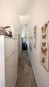 un couloir avec des murs blancs et un couloir avec des papillons sur le mur dans l'établissement Suite Poseidon Golf & Ocean View, à San Miguel de Abona