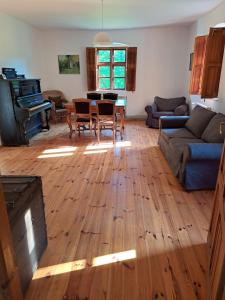 a living room with a wooden floor and a piano at Gospodarstwo Agro-Turystyczne Kuty in Pozezdrze